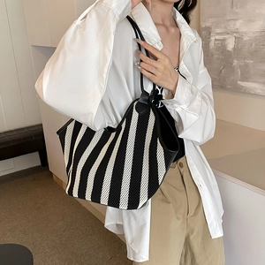 Bolso tote grande de malla con rayas verticales blancas y negras y asas de cuero negro