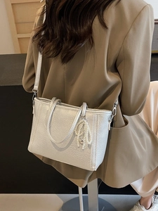 Silver lychee grain tote bag with pearl tassel pendant on a stylish blazer model