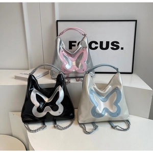 Close-up of butterfly tote bags in metallic colors with chain straps and stud details