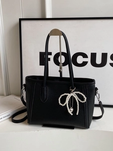 Chic black litchi faux leather tote bag with pearl bow charm and crossbody strap