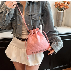 Close-up of pink quilted bucket backpack featuring Clear K metallic letters and drawstring