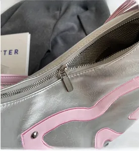 Close-up of silver tote bag showing smooth metal zipper and wavy pattern lining details