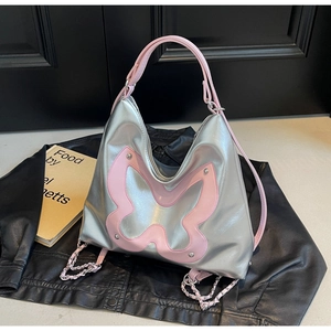 Close-up of Y2K silver tote bag with pink butterfly patch, metal rivets and chain detail