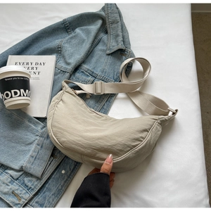 Sac croissant en nylon beige minimaliste avec veste en jean et tasse de café