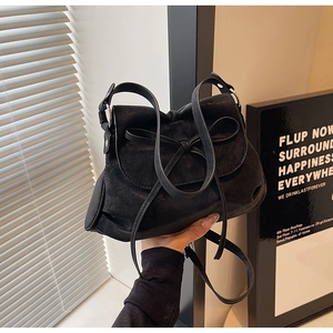 Detailansicht der schwarzen Faltenledertasche mit zarter Schleife und weicher Textur