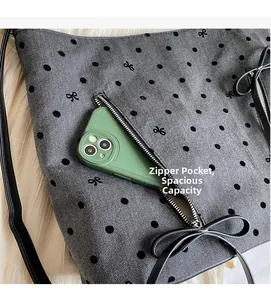 Detail of grey herringbone bag with bow embroidery and zipper pocket for smartphone