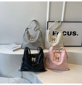 Detail of metallic tote bags in silver, cream, black and pink with rhinestone bows