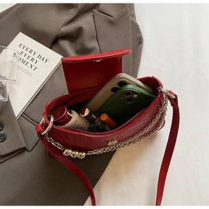 Internal view of red crocodile pattern shoulder bag showing phone and makeup storage