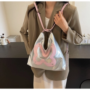 Close-up of metallic silver tote featuring a large pink leather butterfly and metal studs