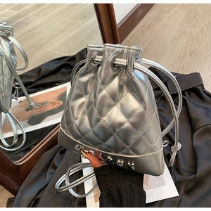 Detail of silver metallic quilted bucket bag with heart pendant and drawstring closure
