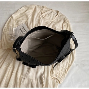Top view of spacious tote interior with zipper pocket, leather straps, and bow texture