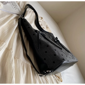 Close-up of large capacity grey tote bag with black leather base and tassel zipper detail