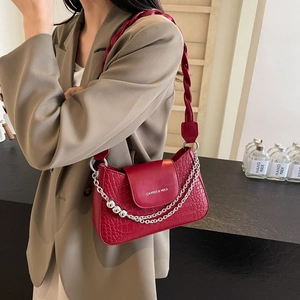 Deep red crocodile texture chain bag with woven strap shown on a fashion model