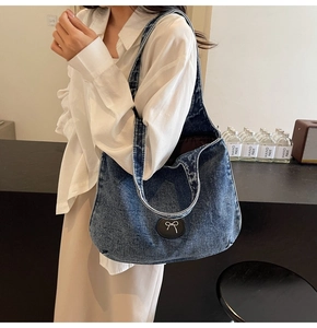 Détail du sac cabas en jean bleu foncé avec patch nœud noir dans un cadre quotidien