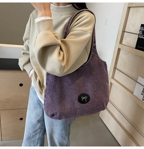 Détail du grand sac cabas en denim violet délavé avec écusson nœud noir élégant