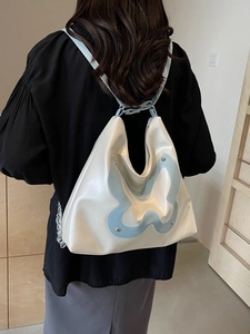 Versatile cream hobo backpack with blue butterfly patch and silver chain detail