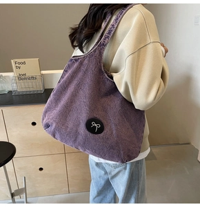 Détail du sac cabas en denim lavé violet orné d'un nœud circulaire noir élégant