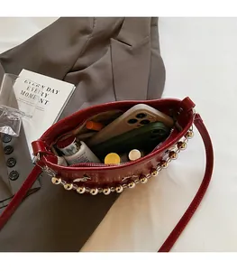 Spacious interior of red glossy bucket bag holding a smartphone and cosmetics
