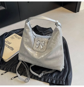 Detail of silver tote bag with metallic bow buckle and crackle texture finish