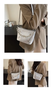 Detail of silver pleated shoulder bag with metal butterfly applique and beaded charms