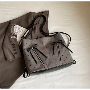 Close-up of retro gray canvas tote with red polka dots and decorative black bows
