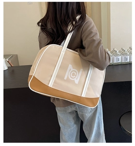 Detailed back view of a large apricot tote bag being worn in a stylish cafe setting