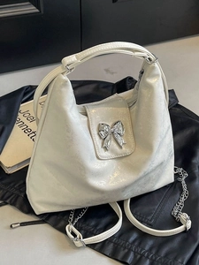 Versatile cream PU leather tote backpack with silver bow clasp on stylish black leather