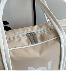 Close-up of smooth dual metal zippers and reinforced white leather handles on tote bag