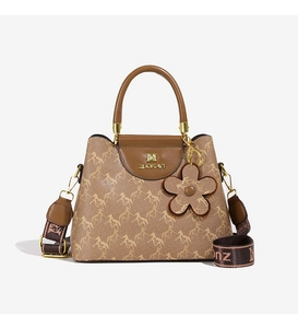 Close-up of brown monogram bucket bag with gold hardware and wide woven strap
