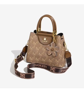 Detail view of bucket bag with horse pattern, ZUOKAYI logo hardware, and floral charm