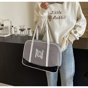 Detail of grey and black patchwork tote bag with long handles in a cafe setting