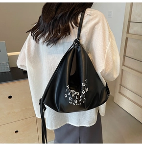 Detail of minimalist black PU tote bag with white letter printing on matte finish