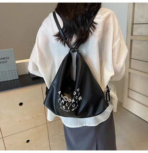 Detailed back view of a black large capacity PU leather backpack with letter patterns