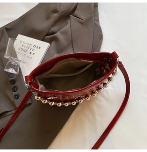 Interior view of red glossy bucket bag showing zipper pocket and spacious lining