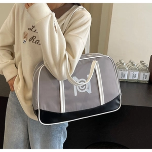 Detail view of large grey tote bag with black leather base and white long handles