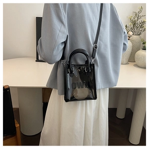 Detailed view of black transparent tote bag with OWN signature logo and leather handle