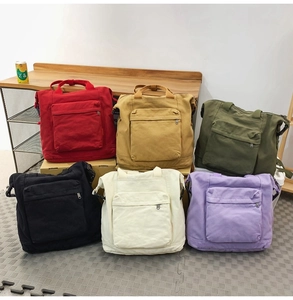 Detailed view of canvas backpacks in six colors with large front zipper pockets