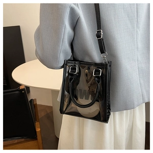 Detail of transparent PVC jelly bag with black trim and adjustable shoulder strap