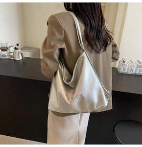 Silver metallic tote bag shown on model with pink alphabet print and spacious design