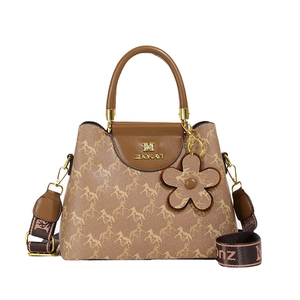 Brown bucket bag with horse print, wide strap and flower charm in 45-degree angle