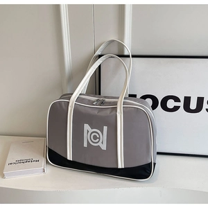 Detail view of large grey, white and black tote bag with circular logo and dual zippers