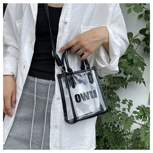 Close-up of clear PVC jelly bag with black OWU print and detachable leather shoulder strap