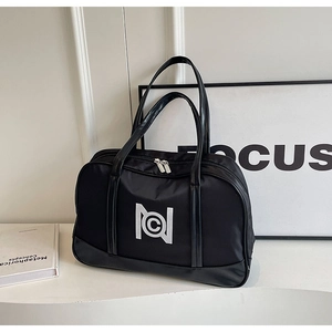 Detail of black waterproof travel bag with white geometric logo and dual metal zippers