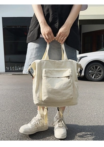 Off-white canvas backpack featuring a front zipper pocket and side buckles for daily use