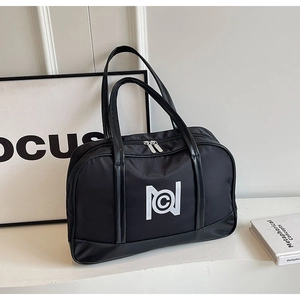 Close-up of a black fitness tote bag featuring a prominent white NC logo and dual handles