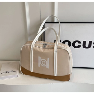 Detail view of beige canvas Boston bag with brown contrast trim and geometric logo