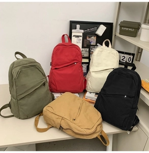 Minimalist canvas backpacks in various colors shown in a natural interior setting
