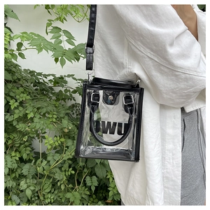 Detail of transparent PVC jelly bag with black trim and logo print on adjustable strap
