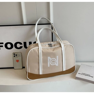 Close-up of beige tote bag with brown leather trim and white geometric logo detail