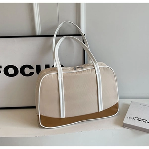 Close-up of stylish beige nylon tote bag with brown leather base and white handles